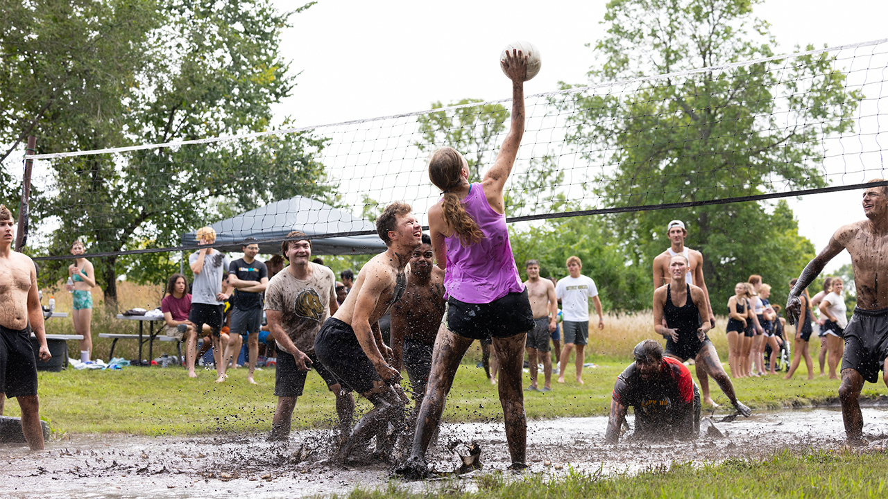 people playing volleyball in the mud